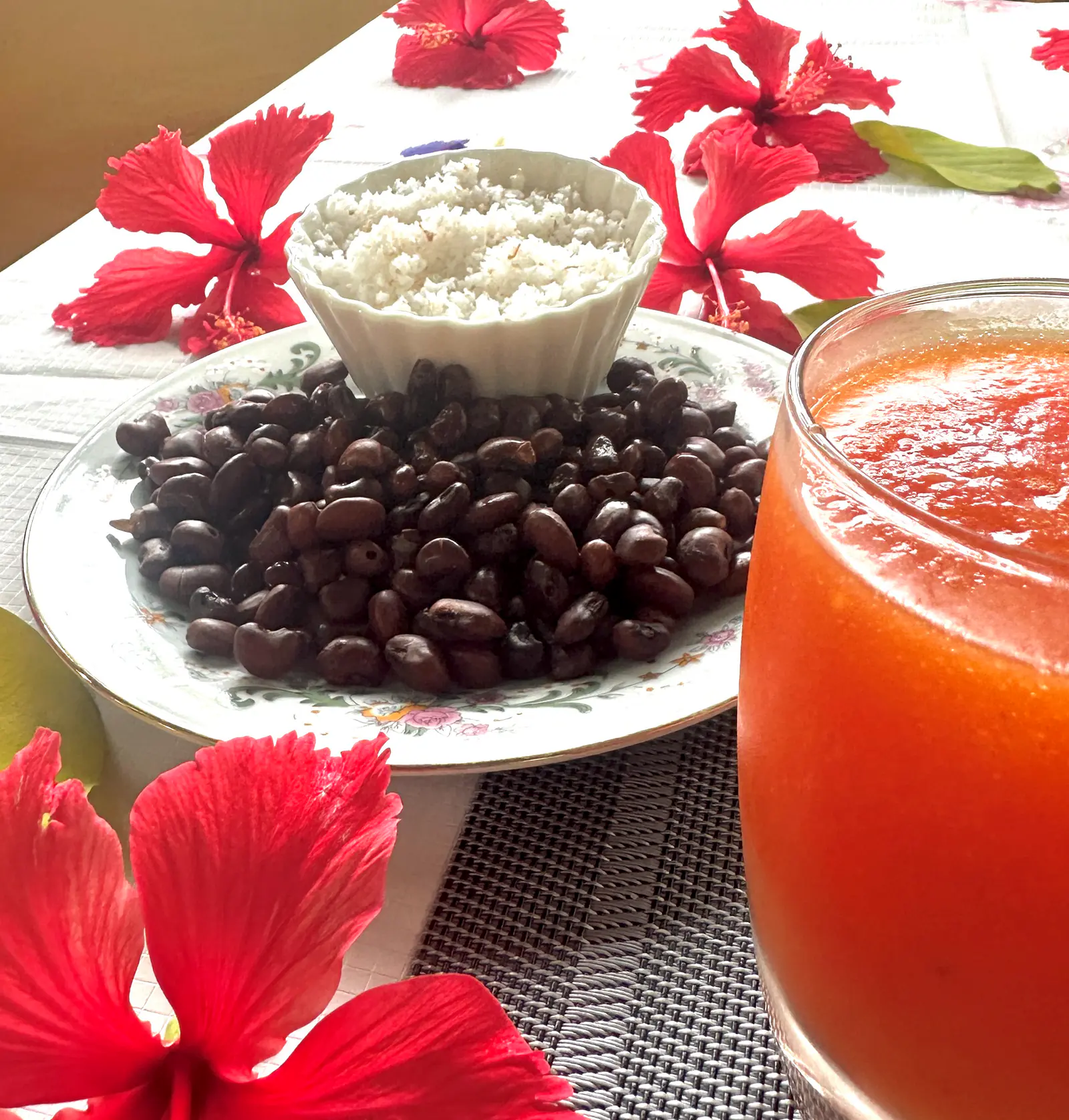 Frühstückstisch mit gerösteten Bohnen, Kokos, frischem Saft und Hibiskusblüten